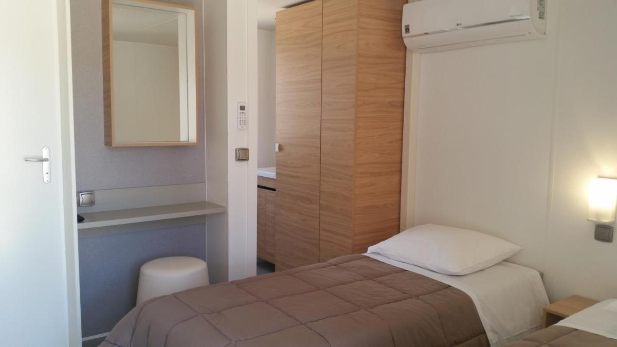 Un ou plusieurs lits dans un hébergement de l'établissement Camping La Pinède