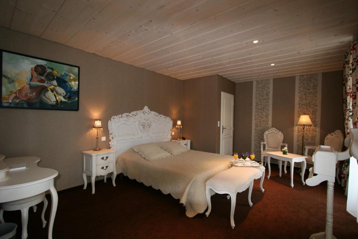 - une chambre avec un lit blanc et un lavabo dans l'établissement Hôtel Restaurant Taillard, à Goumois
