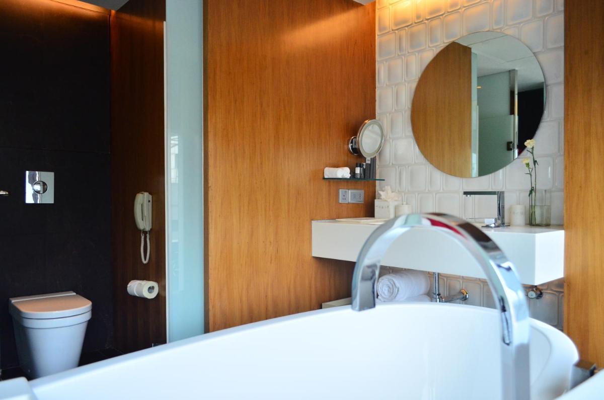 a bathroom with a sink and a mirror and a toilet at The Park Hyderabad, Banjara Hills near Hussain Sagar Lake in Hyderabad a bathroom with a sink and a mirror and a toilet at The Park Hyderabad, Banjara Hills near Hussain Sagar Lake in Hyderabad