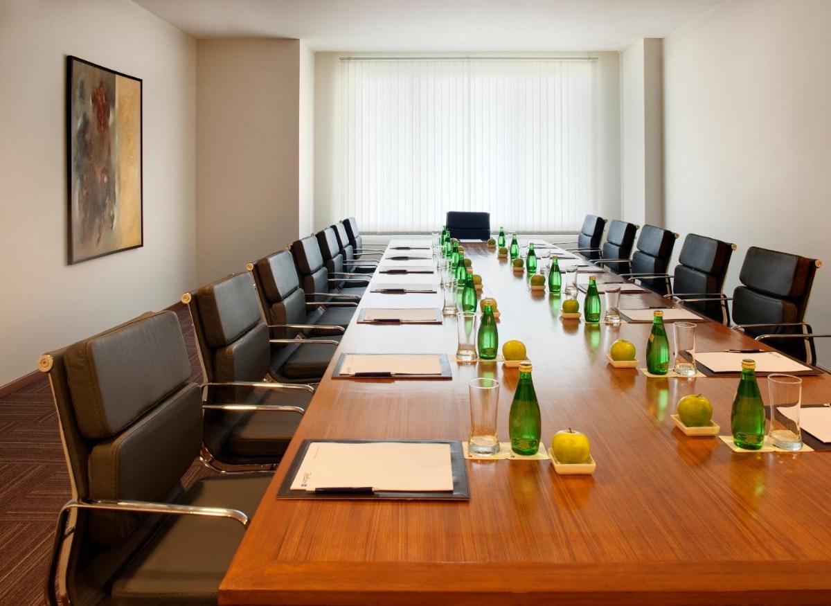 a long table in a room with chairs and bottles at Radisson Blu Plaza Hotel Hyderabad Banjara Hills in Hyderabad a long table in a room with chairs and bottles at Radisson Blu Plaza Hotel Hyderabad Banjara Hills in Hyderabad