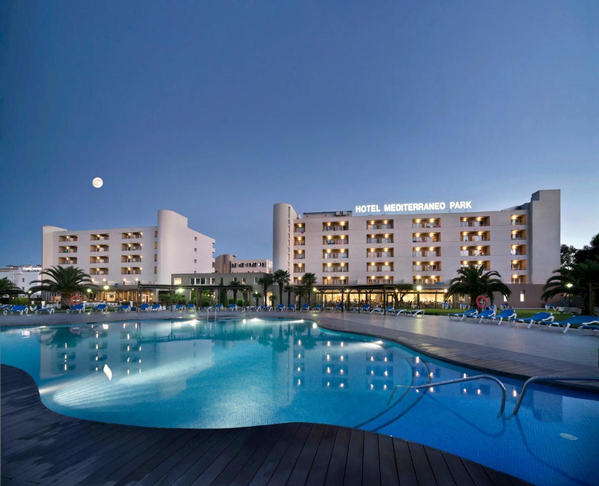 una gran piscina frente a un hotel en Hotel Spa Mediterraneo Park, en Roses una gran piscina frente a un hotel en Hotel Spa Mediterraneo Park, en Roses