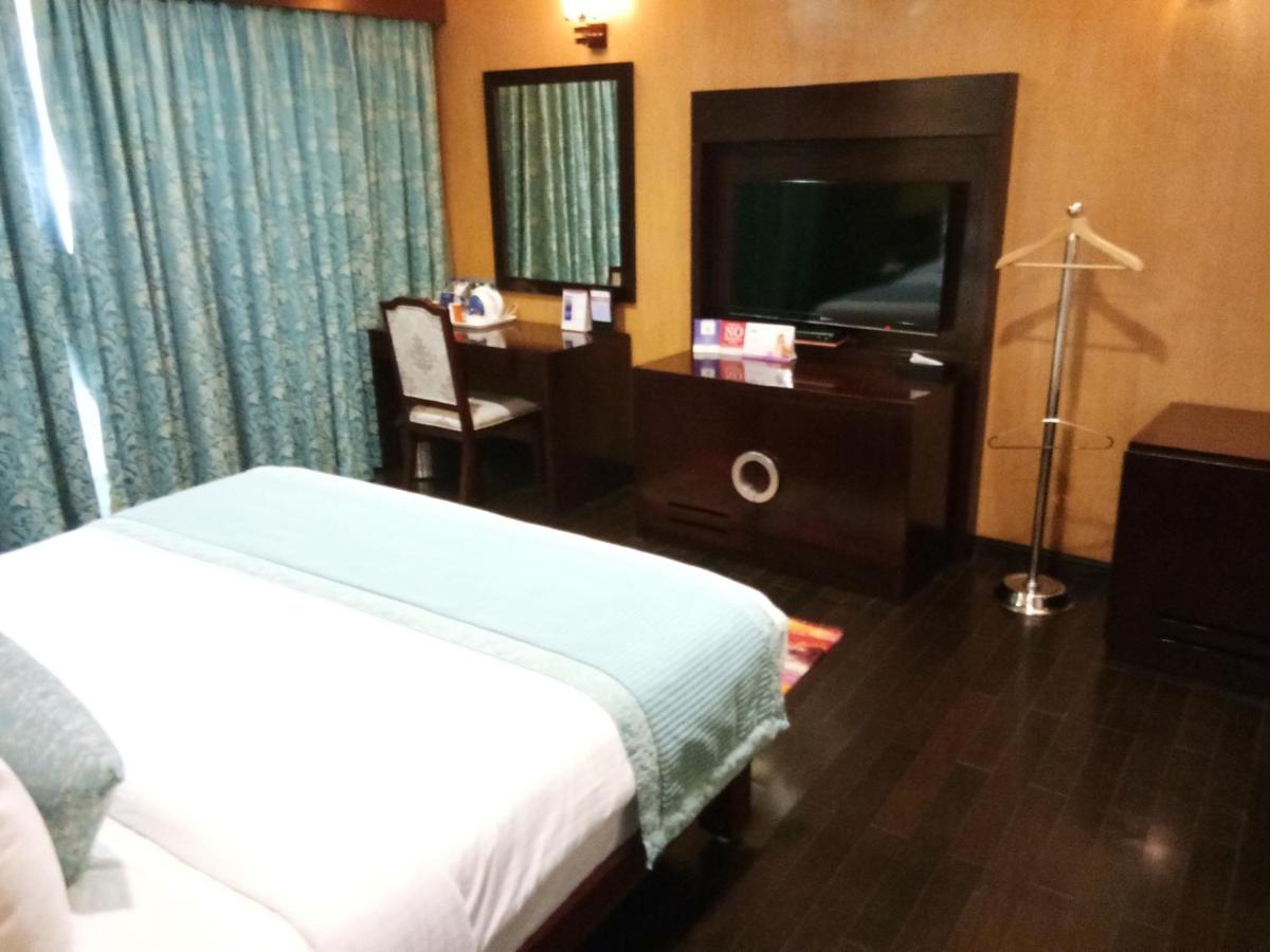 a bedroom with a bed and a desk and a television at Fortune Select Grand Ridge, Tirupati - Member ITC Hotels' Group in Tirupati