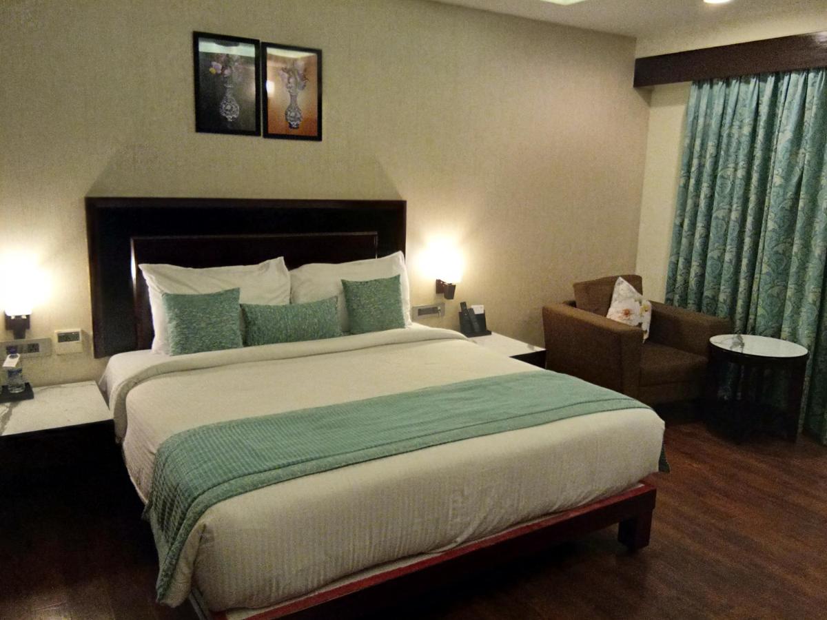 a hotel room with a large bed and a chair at Fortune Select Grand Ridge, Tirupati - Member ITC Hotels' Group in Tirupati