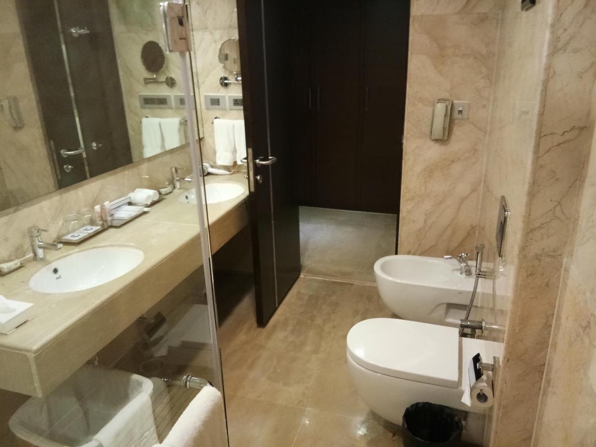 a bathroom with a sink and a toilet and a mirror at Fortune Select Grand Ridge, Tirupati - Member ITC Hotels' Group in Tirupati