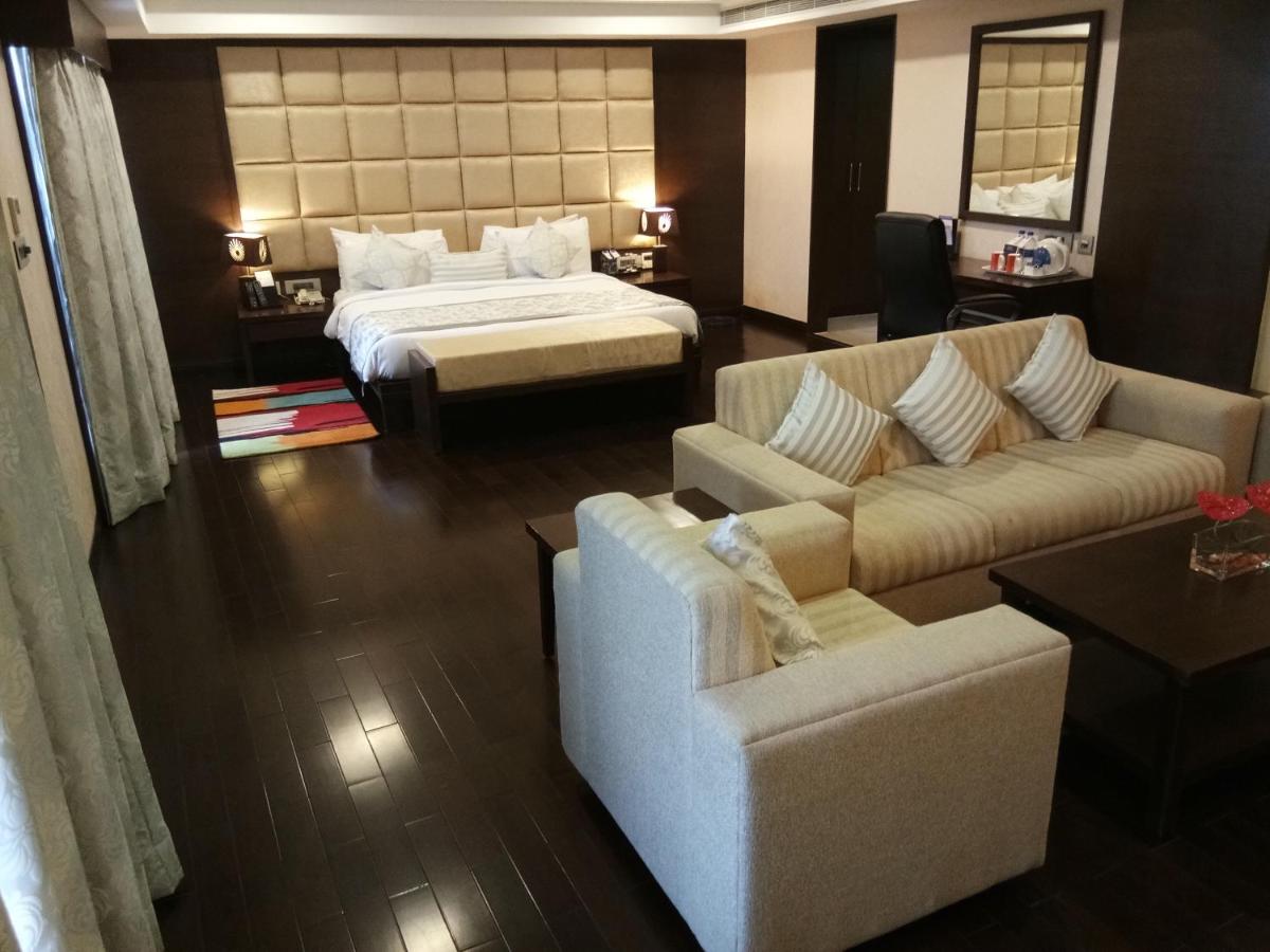 a hotel room with a bed and a couch and a bed at Fortune Select Grand Ridge, Tirupati - Member ITC Hotels' Group in Tirupati