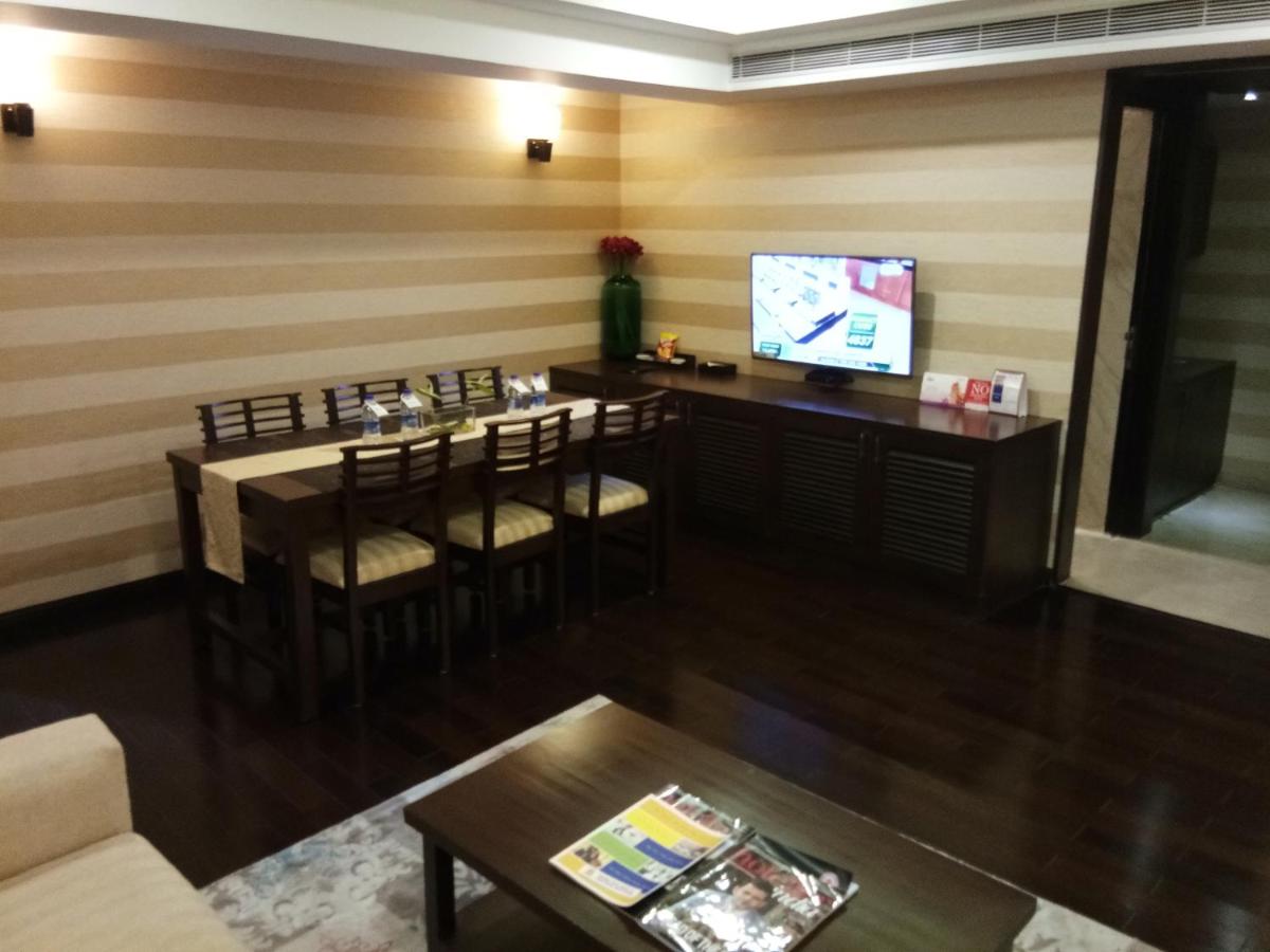 a living room with a bar with chairs and a television at Fortune Select Grand Ridge, Tirupati - Member ITC Hotels' Group in Tirupati