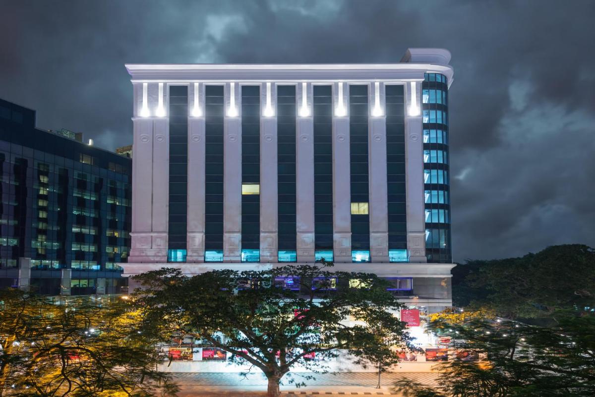 a tall white building with lights on it at Ramada Plaza Chennai in Chennai