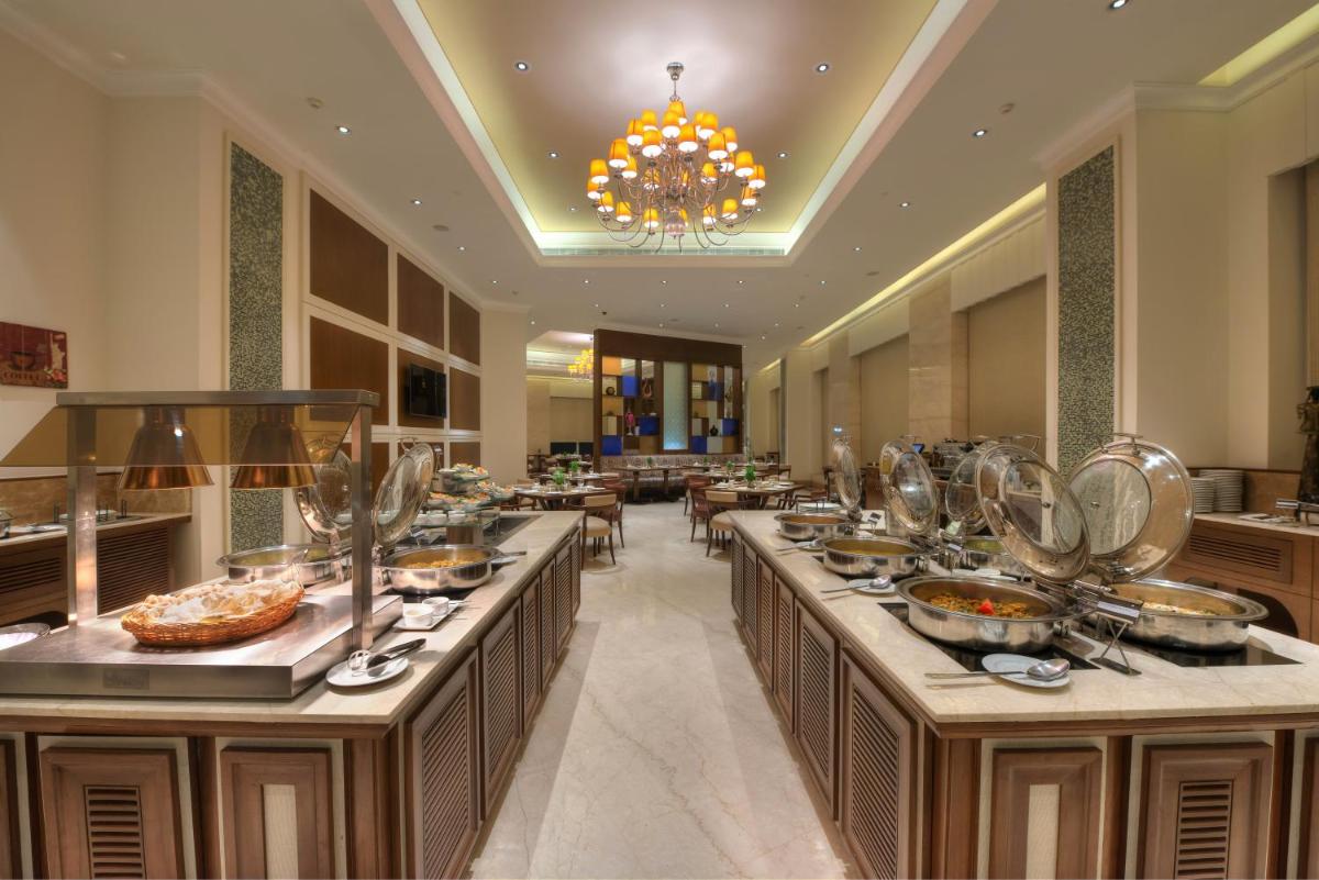 a buffet line in a restaurant with food at Ramada Plaza Chennai in Chennai