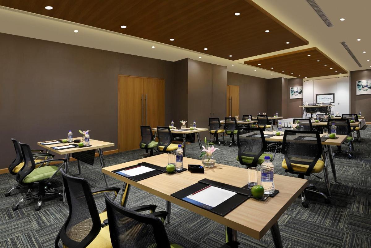 a conference room with tables and chairs in a room at Novotel Chennai OMR in Chennai