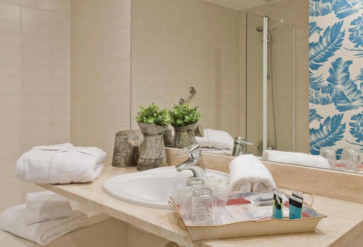 Un mostrador de baño con un lavabo y un espejo. en Hotel Luze El Toro, en Berrioplano