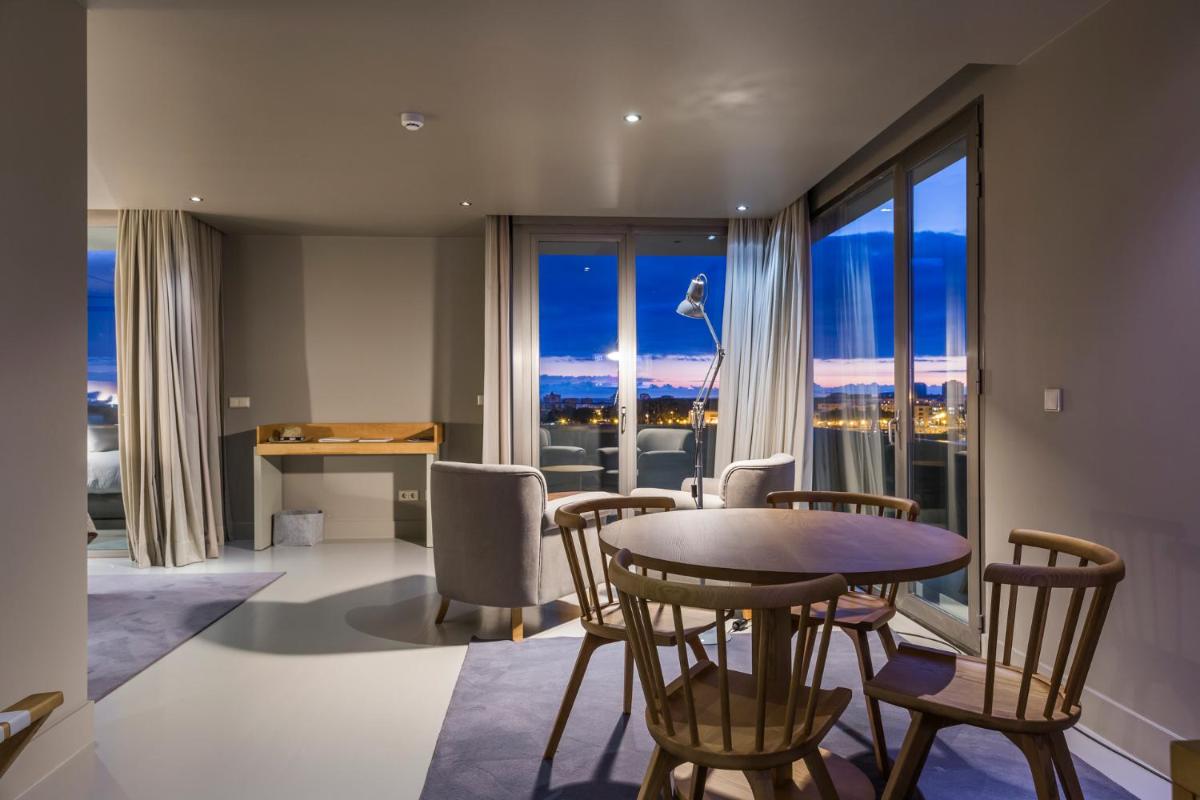 uma sala de estar com uma mesa e cadeiras com vista em Villa C Boutique Hotel em Vila do Conde