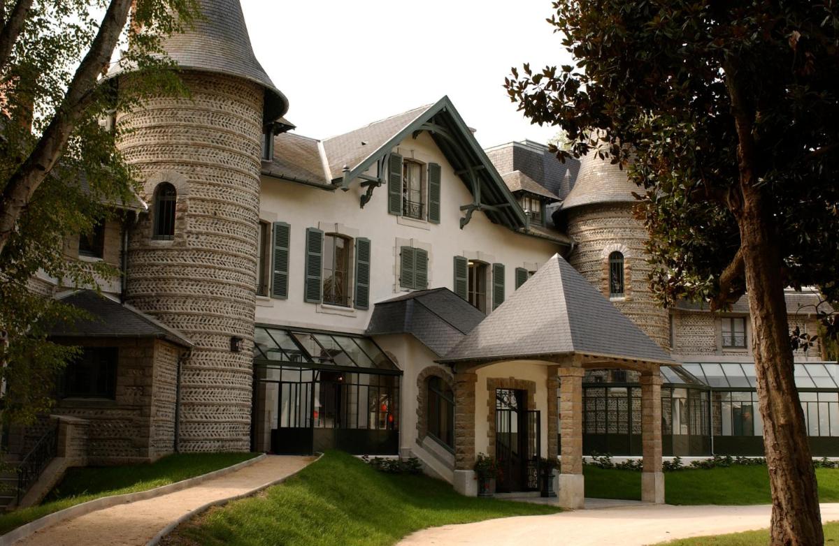 une grande maison en briques avec une tourelle dans l'établissement Hôtel Villa Navarre, à Pau