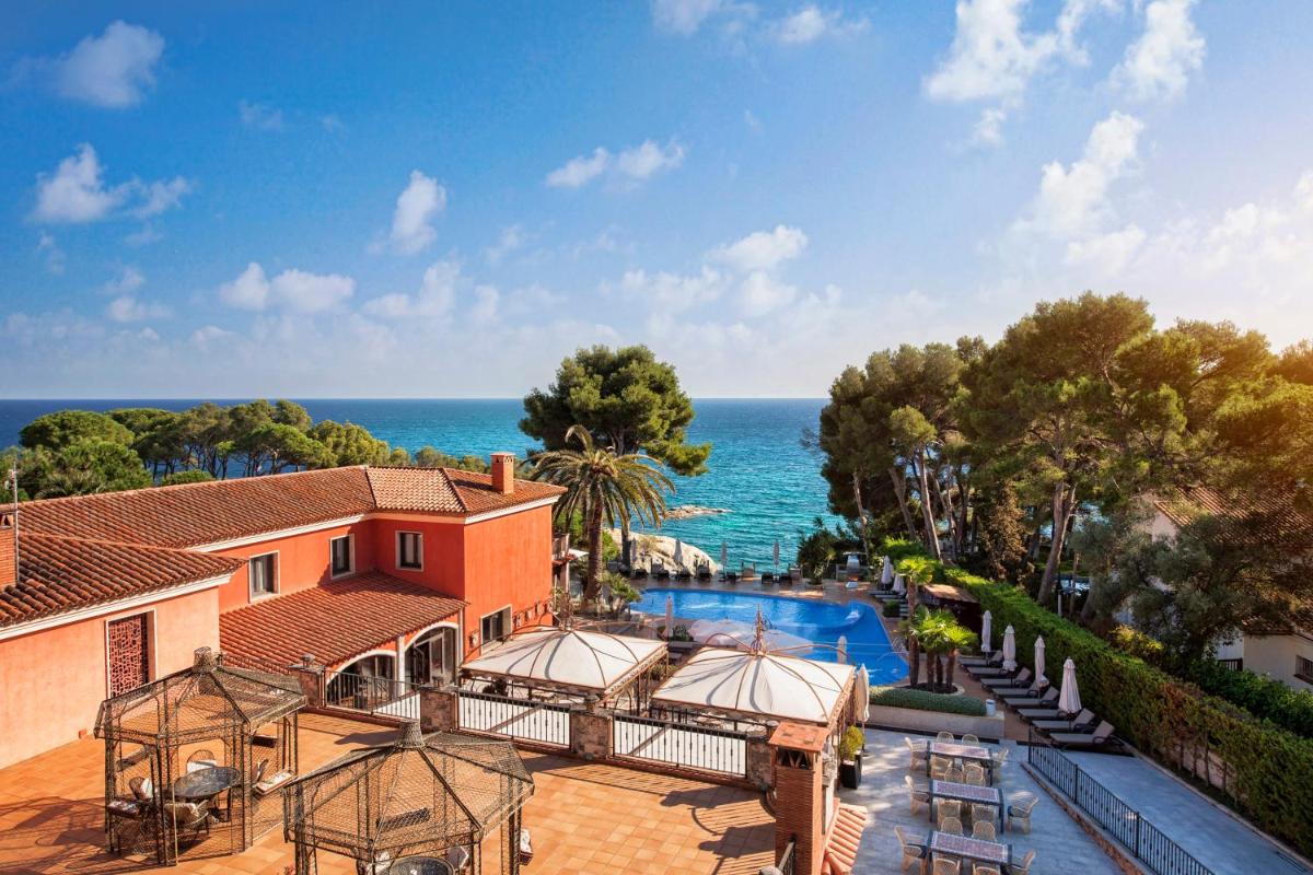 una vista aérea de una casa con piscina y el océano en Hotel Cala del Pi - Adults Only, en Platja d'Aro