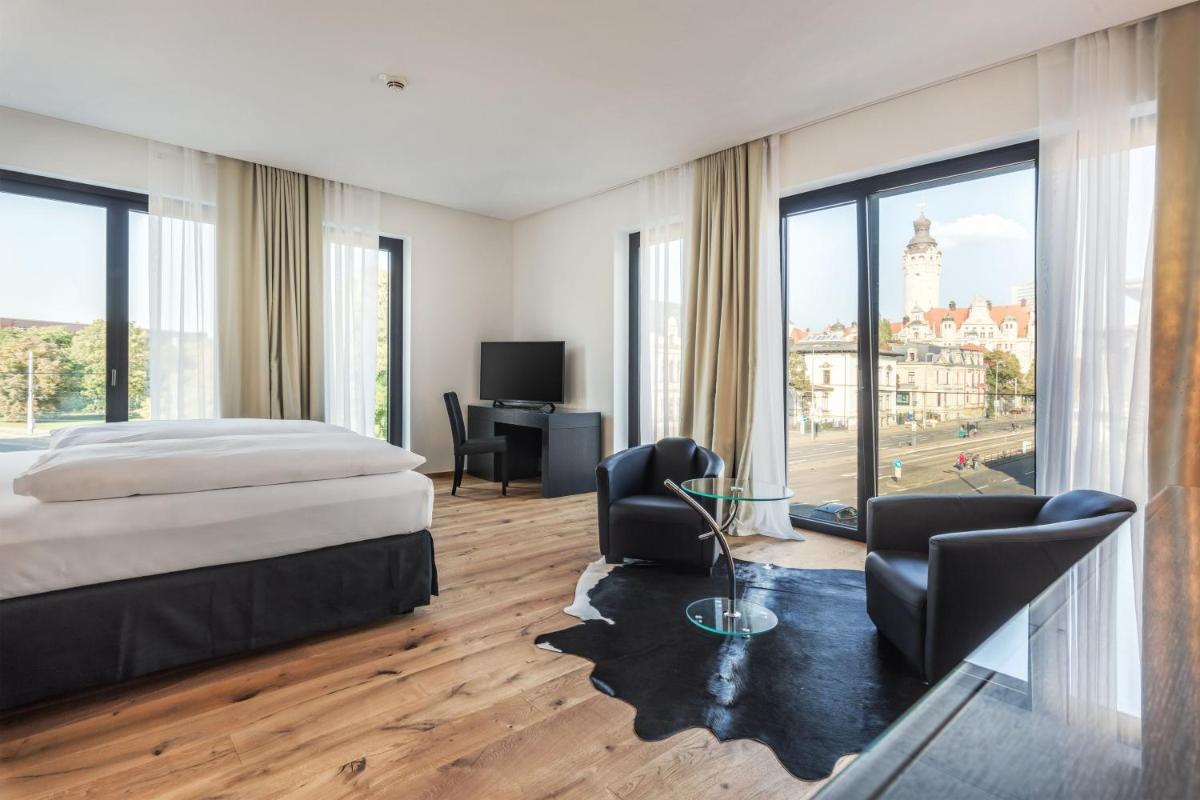 ein Schlafzimmer mit einem Bett und einem Schreibtisch und Stühlen in der Unterkunft Voss Villa in Leipzig ein Schlafzimmer mit einem Bett und einem Schreibtisch und Stühlen in der Unterkunft Voss Villa in Leipzig