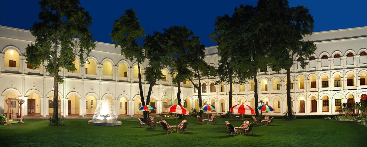 a building with chairs and umbrellas in a courtyard at The Grand Imperial - Heritage Hotel in Agra