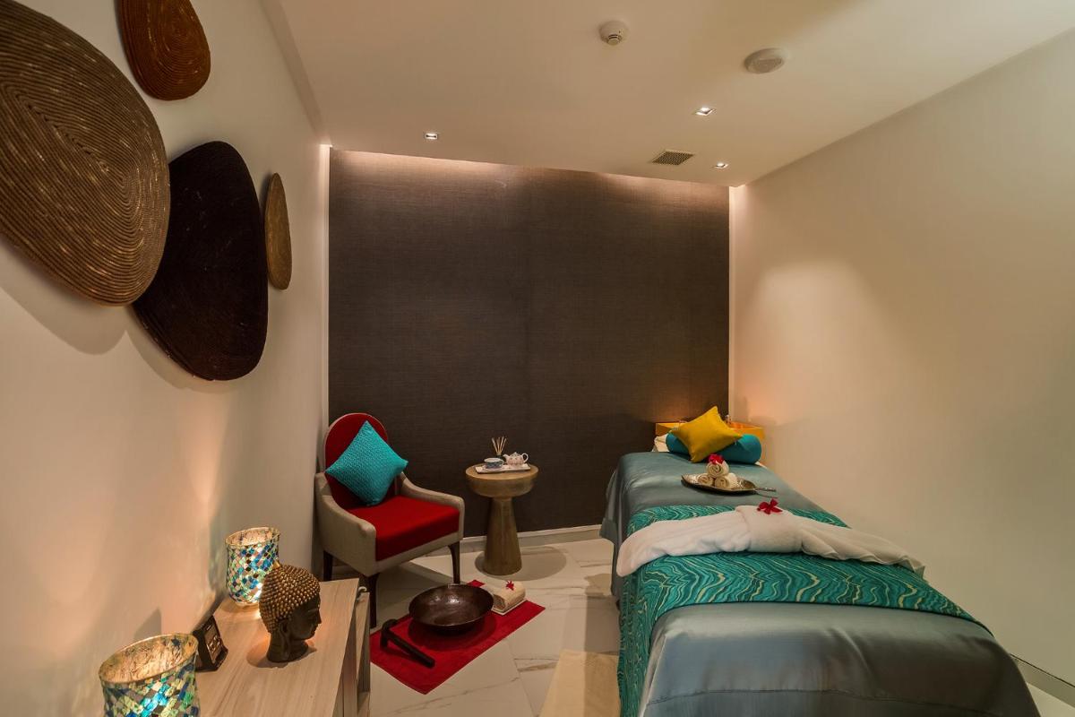 a bedroom with a bed and a red chair at Welcomhotel by ITC Hotels, RaceCourse, Coimbatore in Coimbatore
