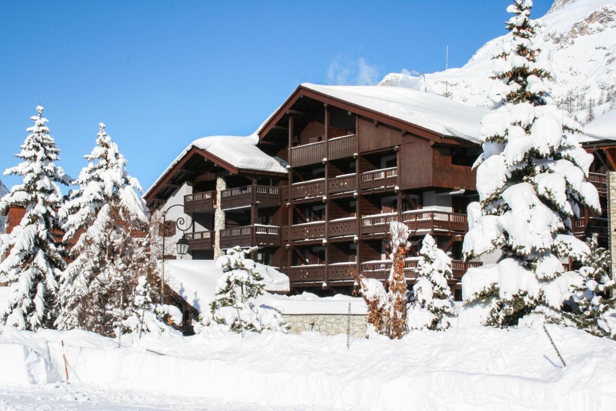 un lodge de ski avec des arbres enneigés devant lui dans l'établissement La Savoyarde, à Val dʼIsère