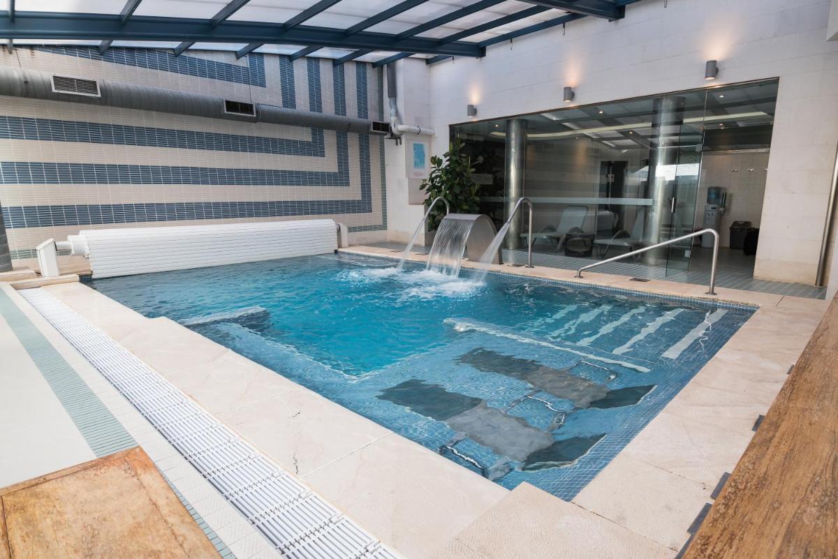 una piscina con cascada en un edificio en ARVA Spa París, en León