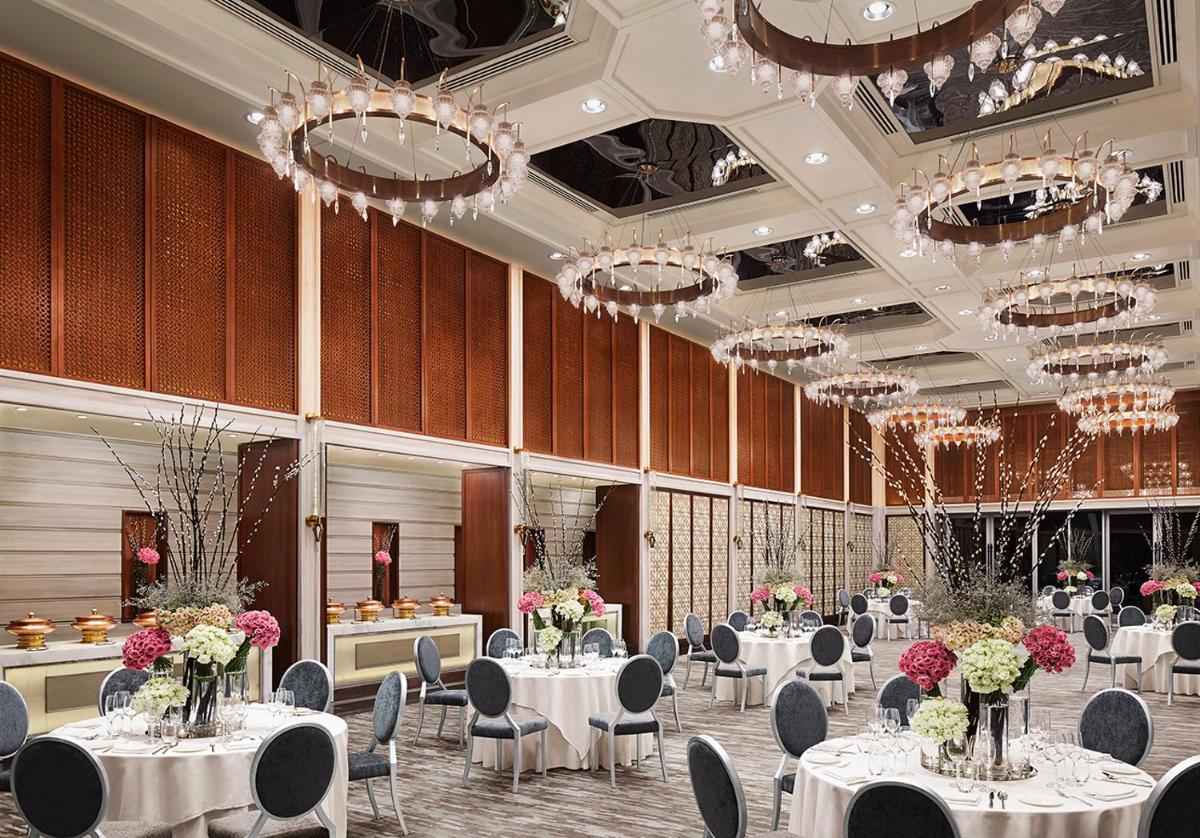 a banquet hall with white tables and chairs and chandeliers at Four Seasons Hotel Mumbai in Mumbai