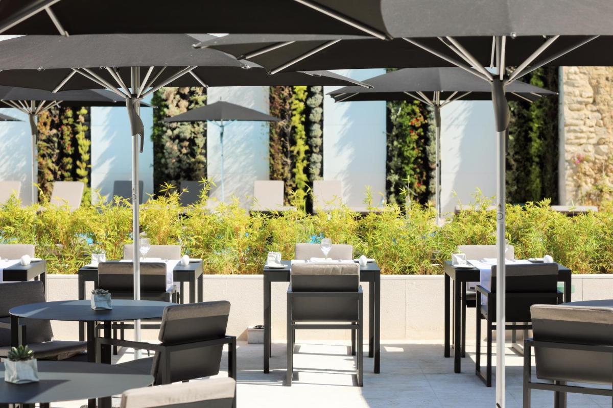 um restaurante com mesas e cadeiras debaixo de guarda-sóis em Iberostar Selection Lisboa em Lisboa mais 109 fotografias