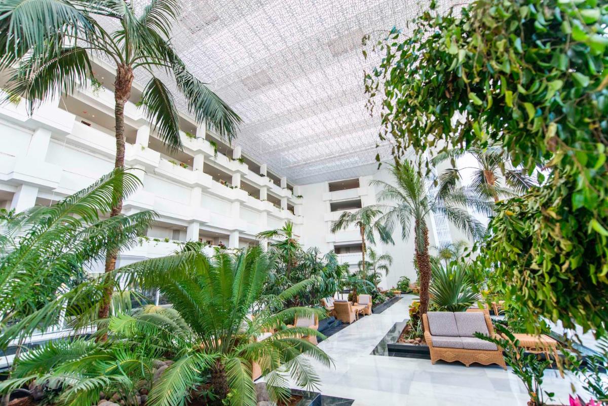 Un edificio con palmeras y plantas. en Spring Hotel Vulcano, en Playa de las Américas