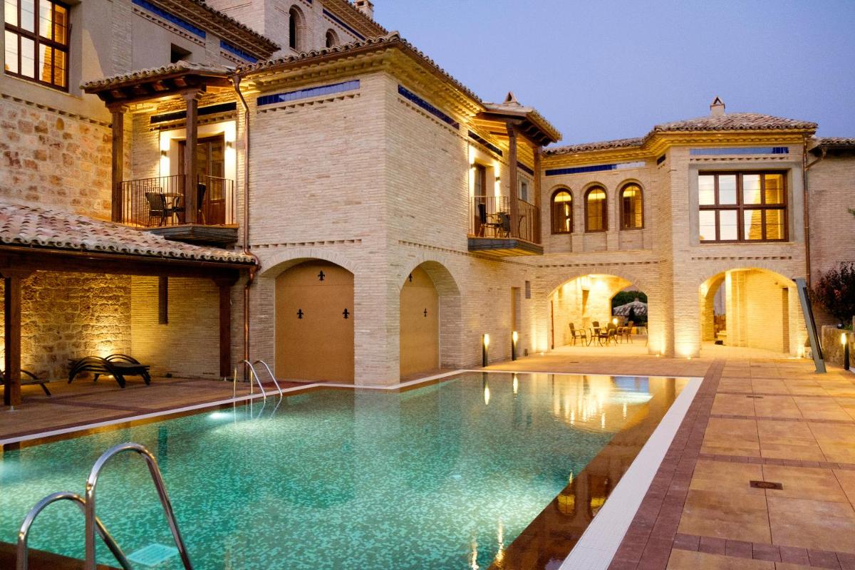 una finca con piscina frente a un edificio en Hotel Villa de Alquézar, en Alquézar