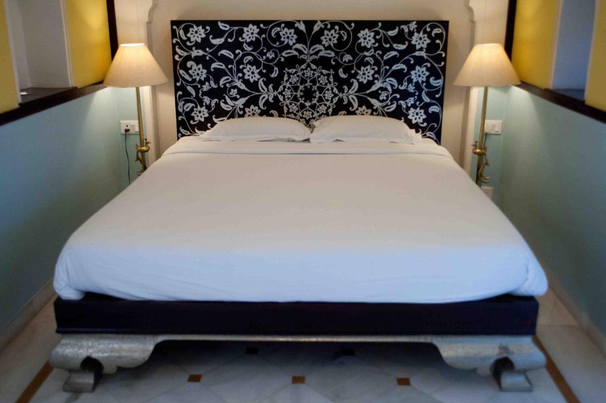a white bed with a black and white headboard at Royal Heritage Haveli - By Leisure Hotels in Jaipur