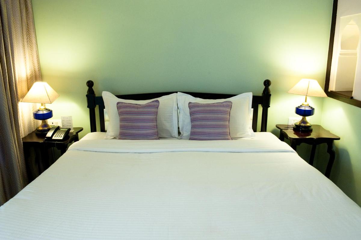 a bedroom with a large white bed with two lamps at Royal Heritage Haveli - By Leisure Hotels in Jaipur
