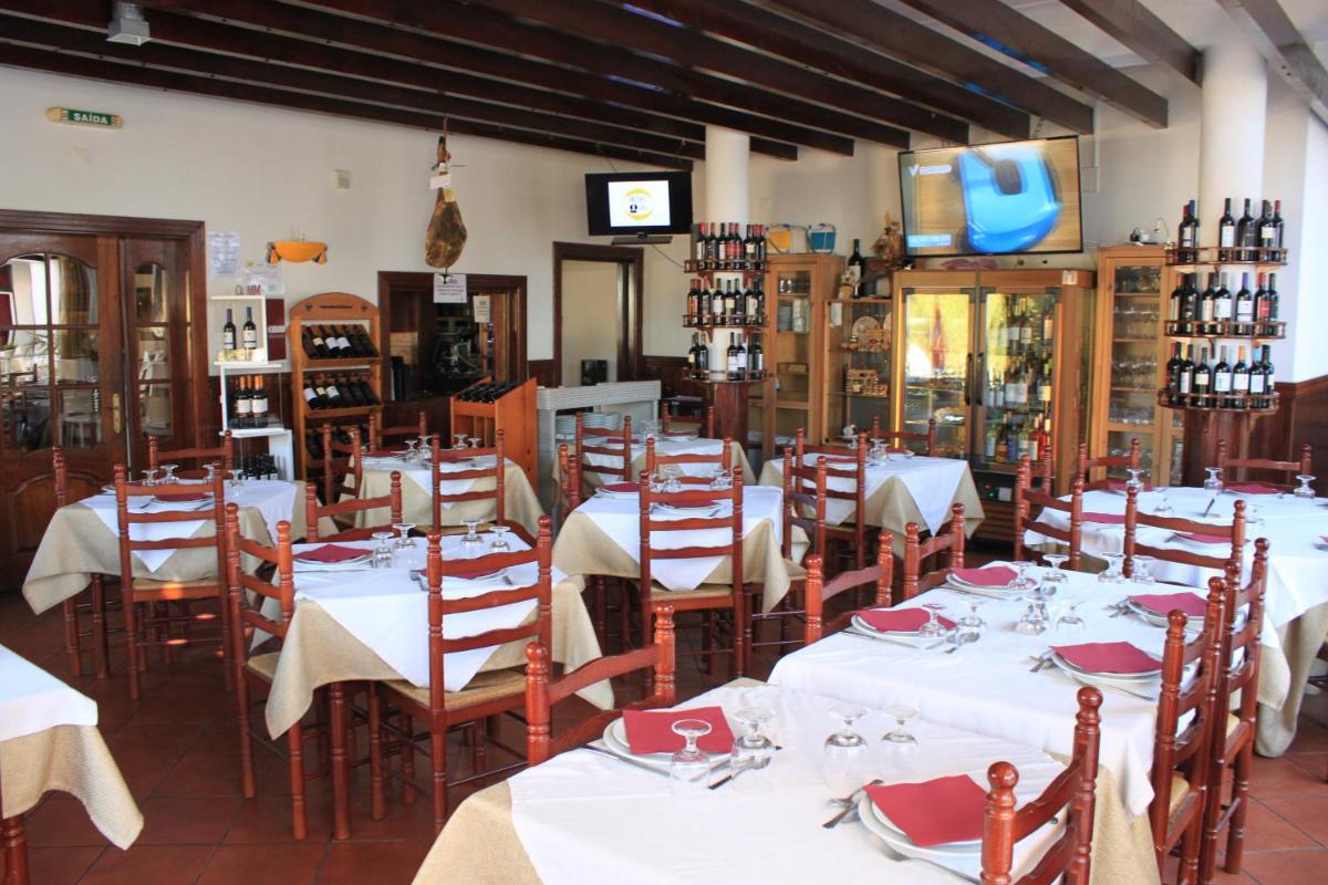 um restaurante com mesas e cadeiras com toalhas de mesa brancas em Hotel O Gato & Spa em Odivelas
