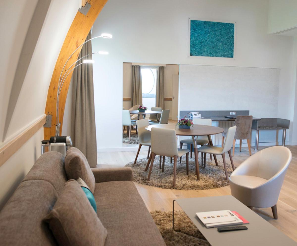un salon avec un canapé et une table dans l'établissement Impérial Palace, à Annecy