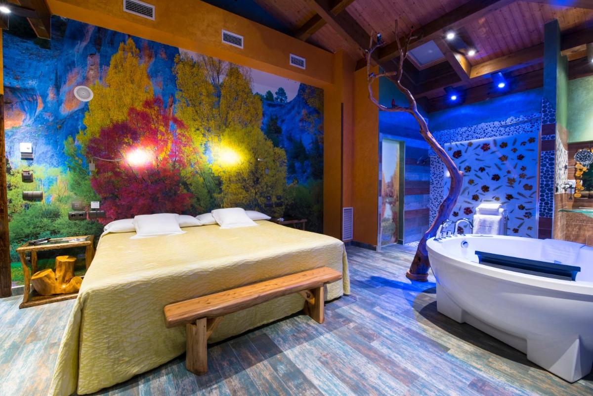 un dormitorio con una cama y una bañera en Hotel SPA El Lagar de Isilla, en La Vid y Barrios