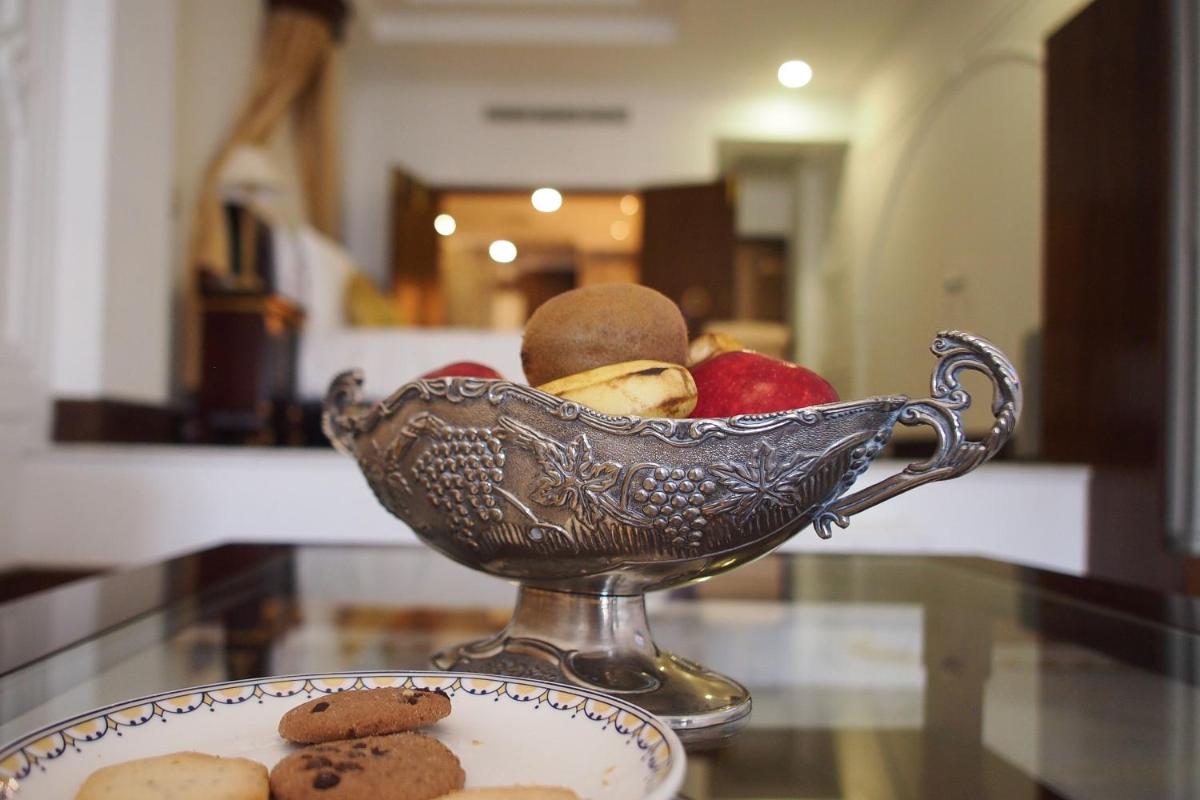a bowl of fruit and cookies on a table at The Raj Palace (Small Luxury Hotels of the World) in Jaipur
