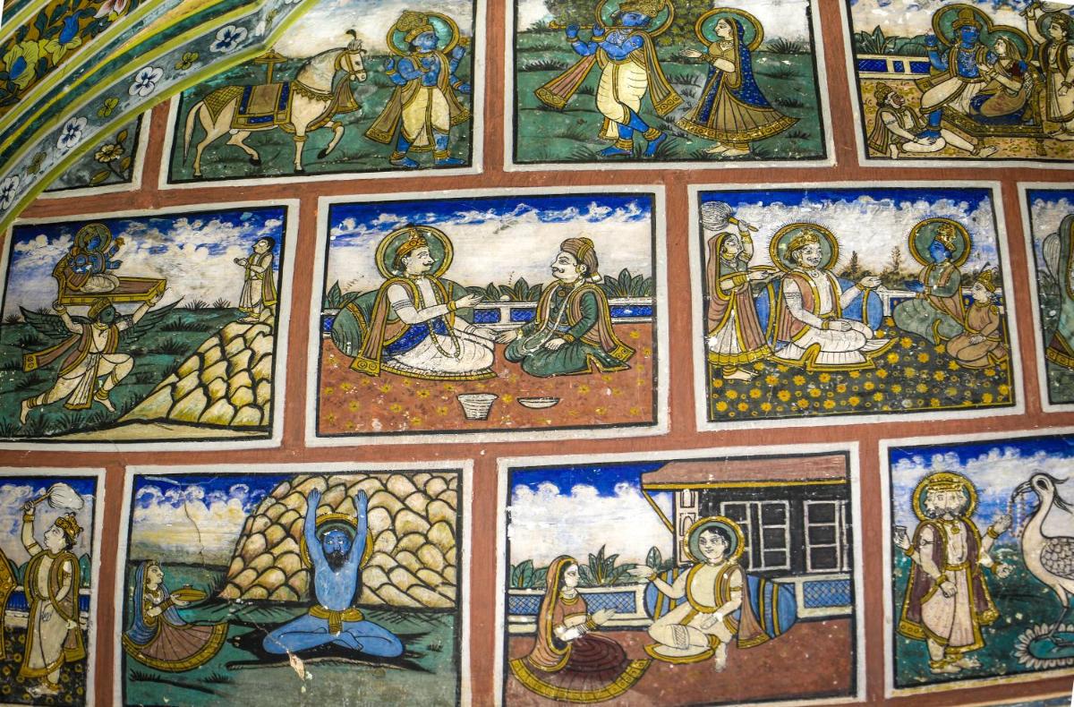 a wall with many paintings on the wall at The Raj Palace (Small Luxury Hotels of the World) in Jaipur