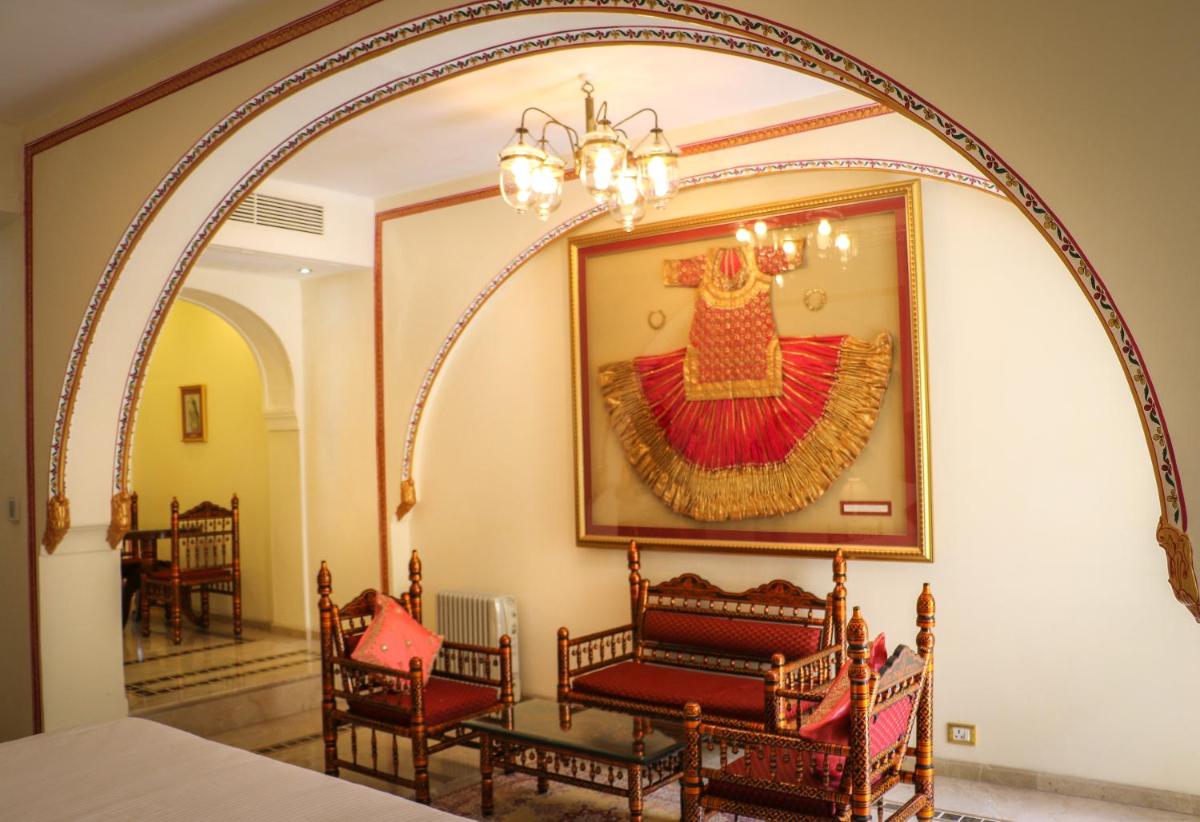 a room with a picture of a dress on the wall at The Raj Palace (Small Luxury Hotels of the World) in Jaipur
