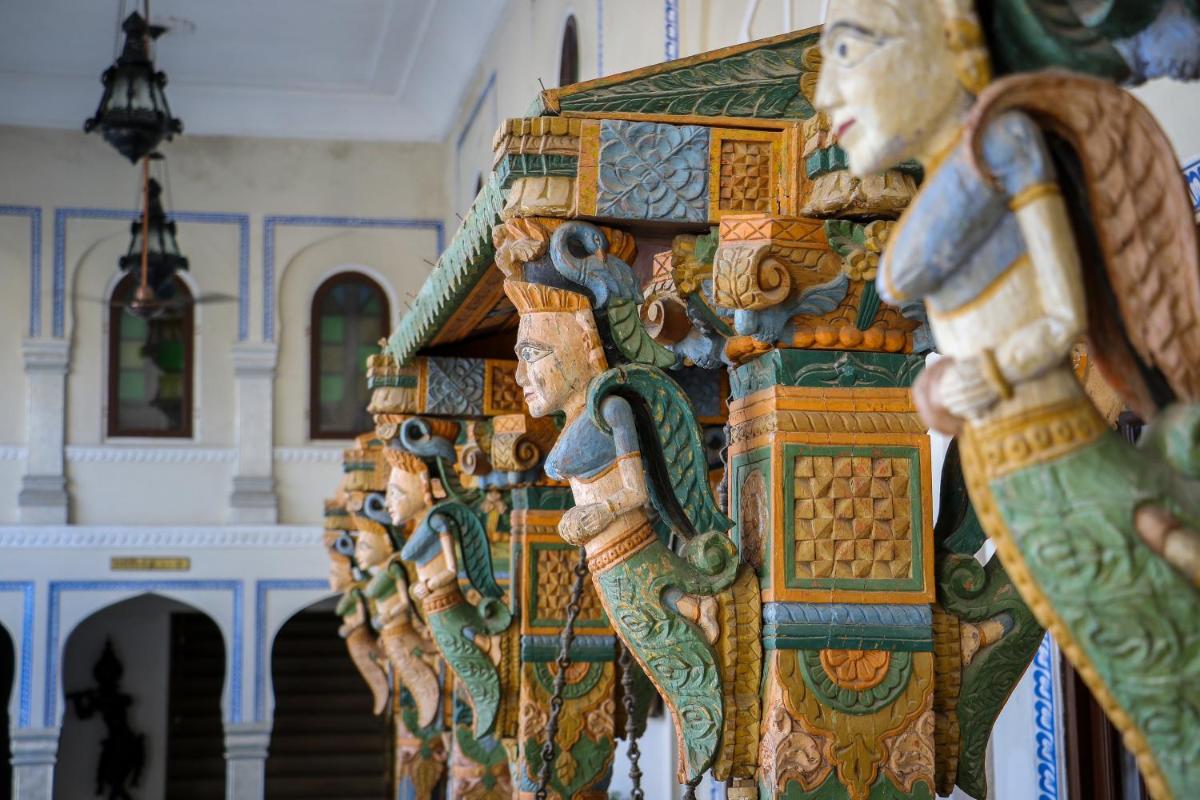 a group of wooden figurines in a room at The Raj Palace (Small Luxury Hotels of the World) in Jaipur