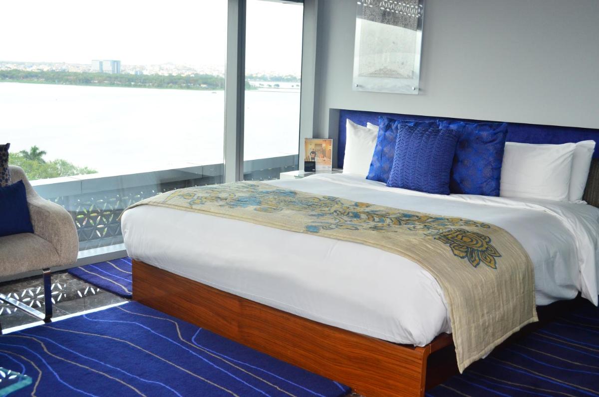 a bedroom with a large bed with blue pillows at The Park Hyderabad, Banjara Hills near Hussain Sagar Lake in Hyderabad a bedroom with a large bed with blue pillows at The Park Hyderabad, Banjara Hills near Hussain Sagar Lake in Hyderabad