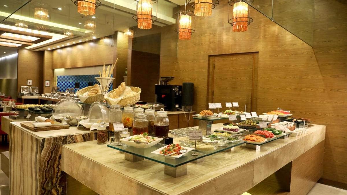 a buffet line in a restaurant with food on it at Hotel Royal Orchid Jaipur, Tonk Road in Jaipur