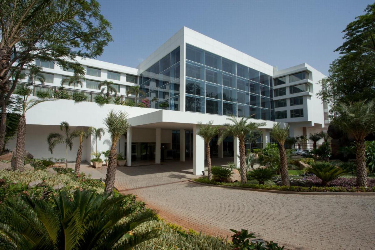 an office building with palm trees in front of it at Radisson Blu Plaza Hotel Hyderabad Banjara Hills in Hyderabad an office building with palm trees in front of it at Radisson Blu Plaza Hotel Hyderabad Banjara Hills in Hyderabad