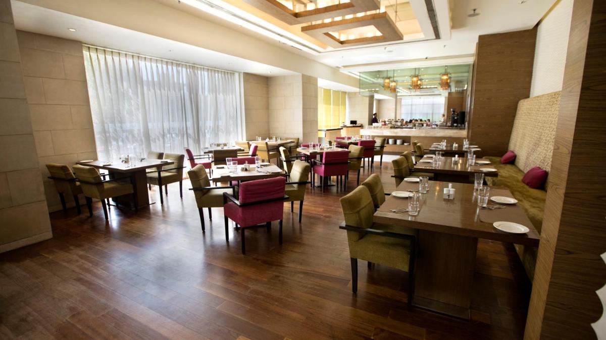 a dining room with tables and chairs in a restaurant at Hotel Royal Orchid Jaipur, Tonk Road in Jaipur +71 photos