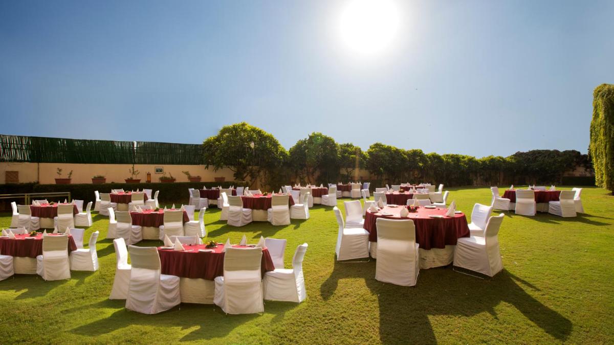 a group of tables and chairs in a field at Hotel Royal Orchid Jaipur, Tonk Road in Jaipur
