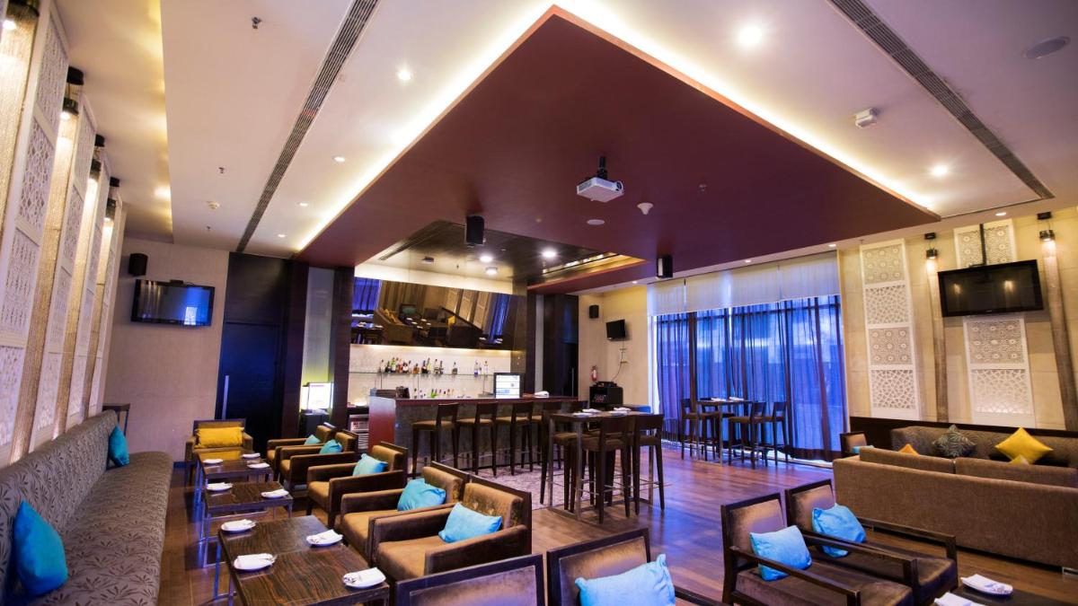 a restaurant with couches and tables and a bar at Hotel Royal Orchid Jaipur, Tonk Road in Jaipur