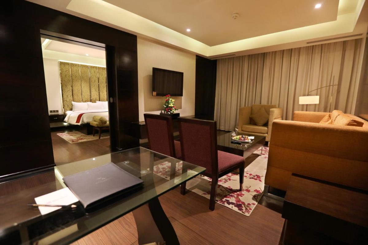 a hotel room with a desk and a bedroom at Hotel Royal Orchid Jaipur, Tonk Road in Jaipur