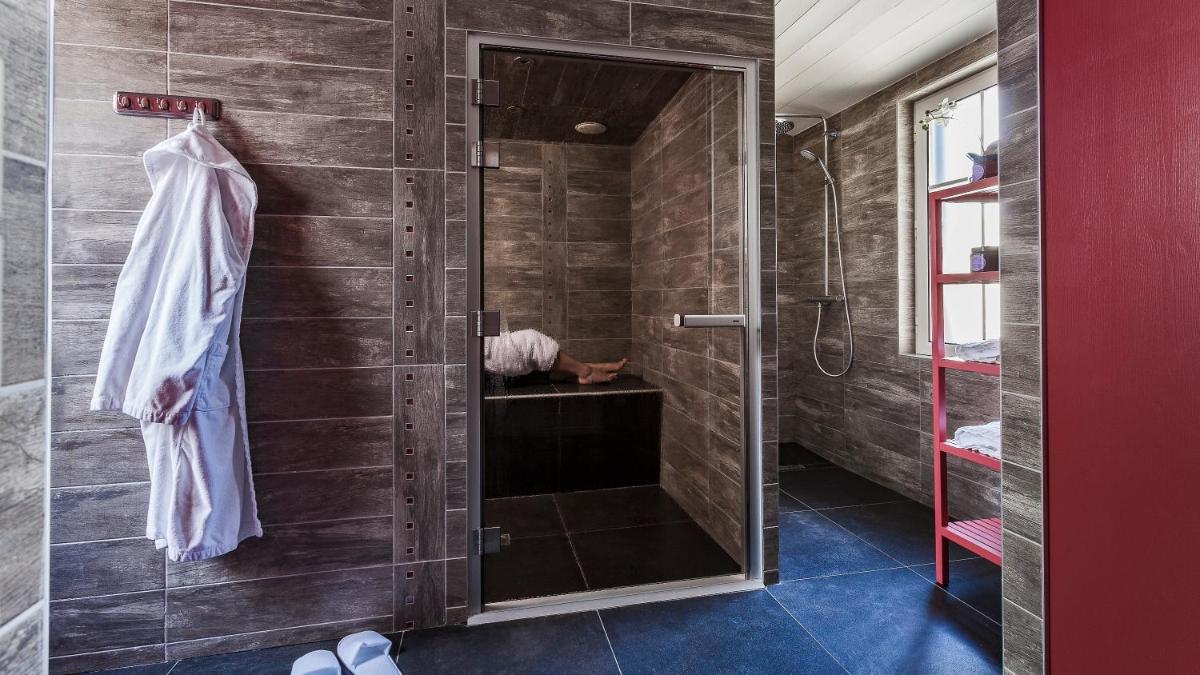 une salle de bain avec une douche avec une porte vitrée dans l'établissement Hotel Les Bois Flottais, au Bois-Plage-en-Ré