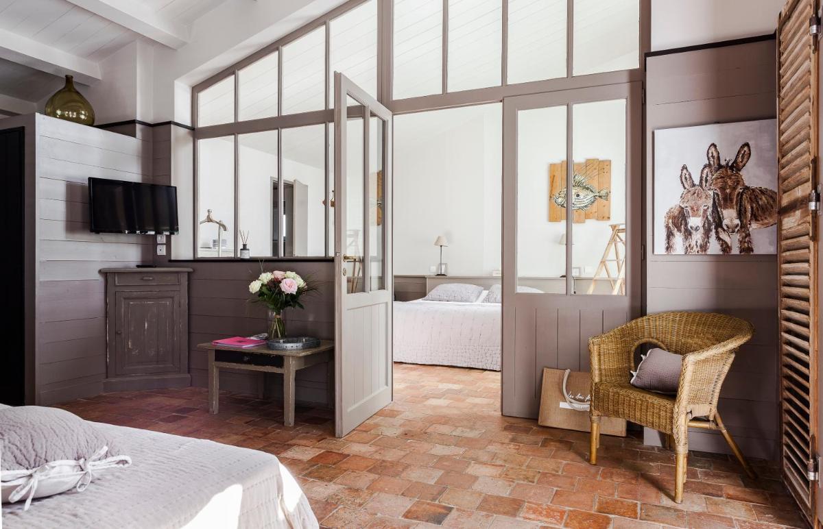 une chambre avec un lit et une table avec une chaise dans l'établissement Hotel Les Bois Flottais, au Bois-Plage-en-Ré