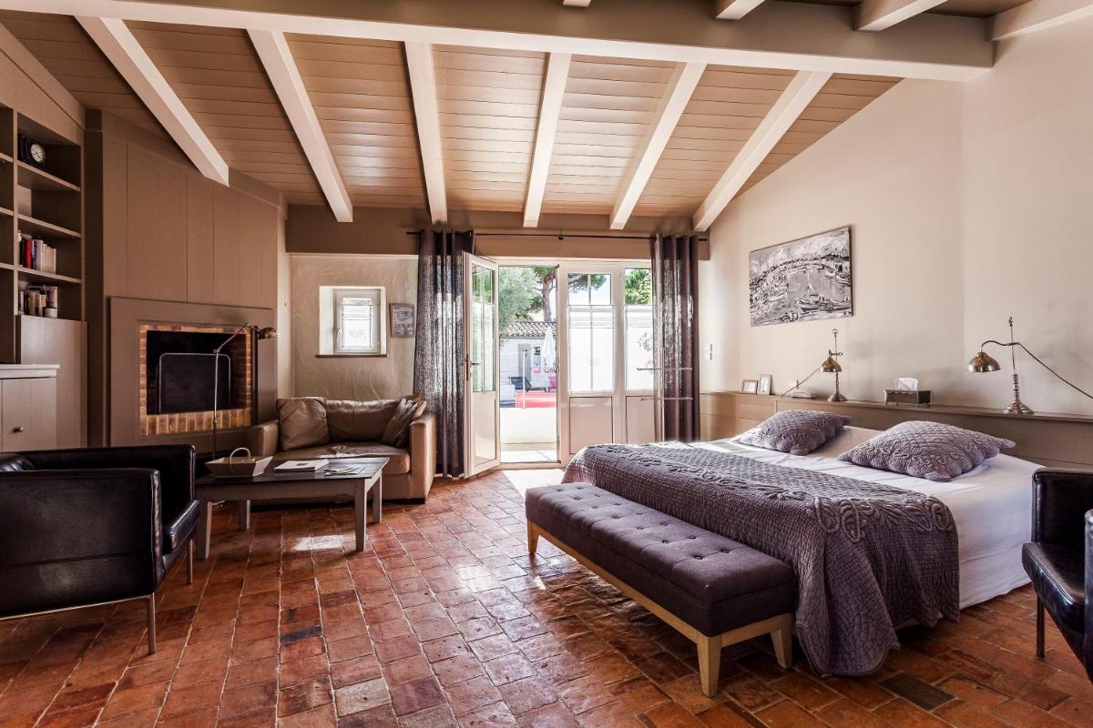 une chambre avec un grand lit et un salon dans l'établissement Hotel Les Bois Flottais, au Bois-Plage-en-Ré 40 autres photos
