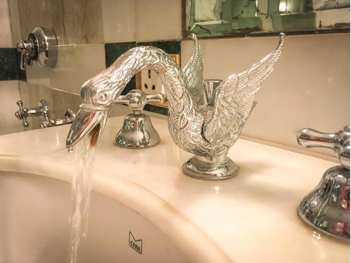 a bathroom sink with water coming out of a faucet at The Raj Palace (Small Luxury Hotels of the World) in Jaipur