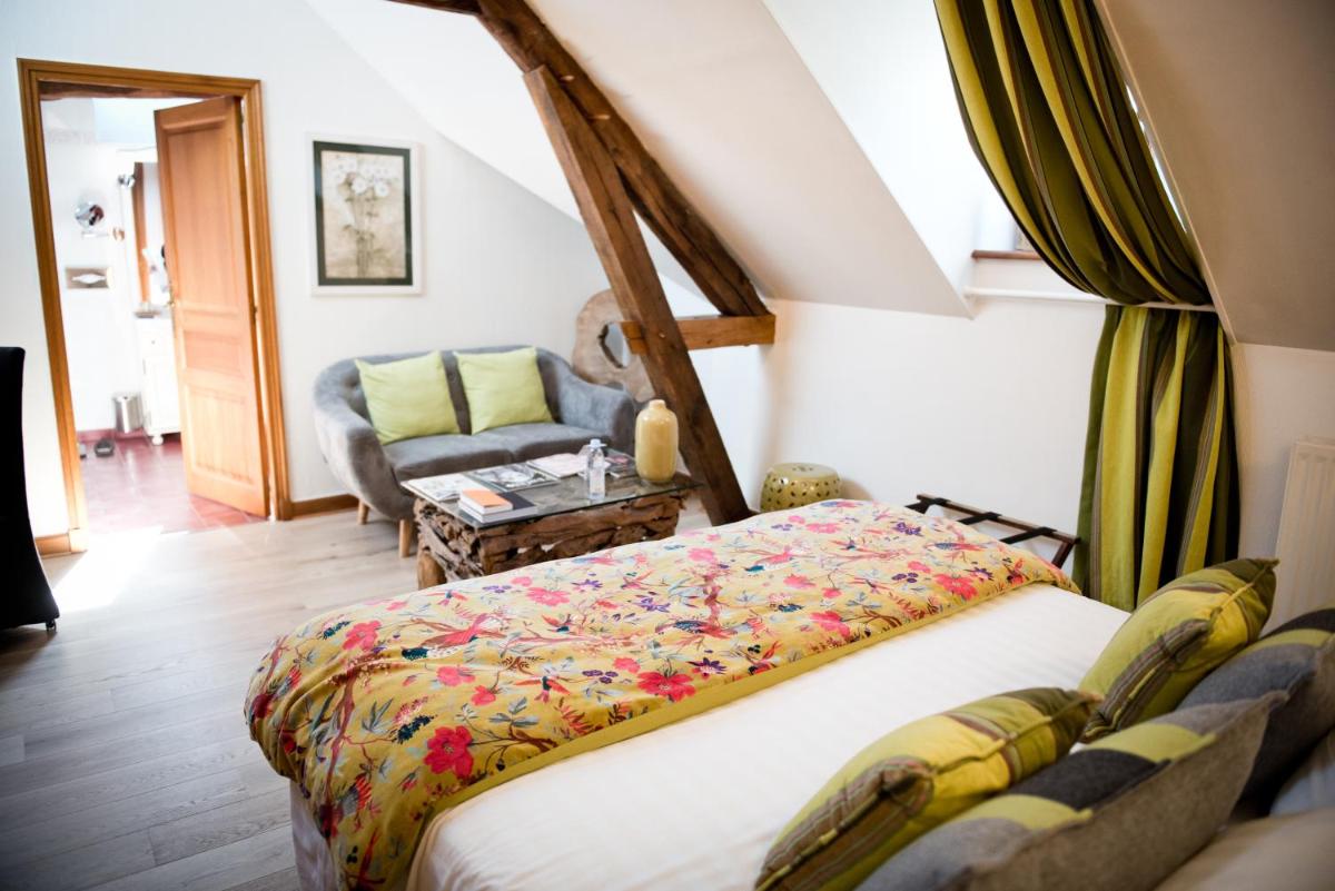 une chambre avec un lit et un canapé dans l'établissement Domaine De Barive, à Sainte-Preuve