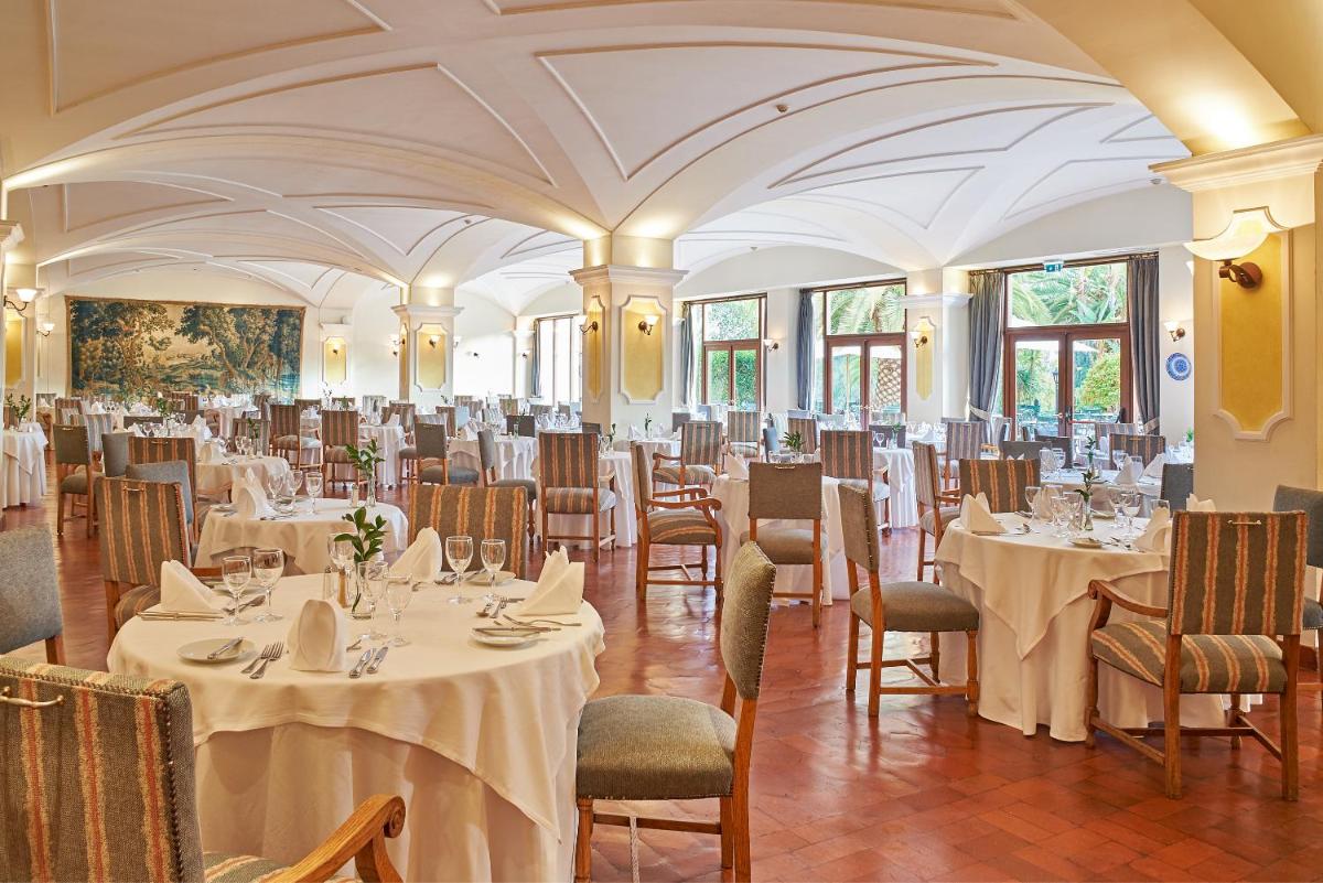 um salão de banquetes com mesas e cadeiras em uma sala em Penina Hotel & Golf Resort em Portimão