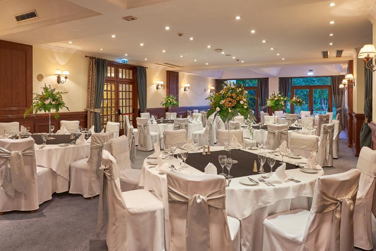 um salão de banquetes com mesas e cadeiras brancas numa sala em Penina Hotel & Golf Resort em Portimão mais 50 fotografias