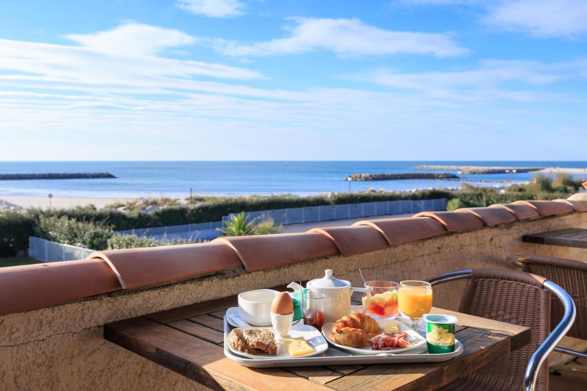 - un plateau de petit-déjeuner sur une table avec vue sur la plage dans l'établissement Thalacap Camargue, à Saintes-Maries-de-la-Mer